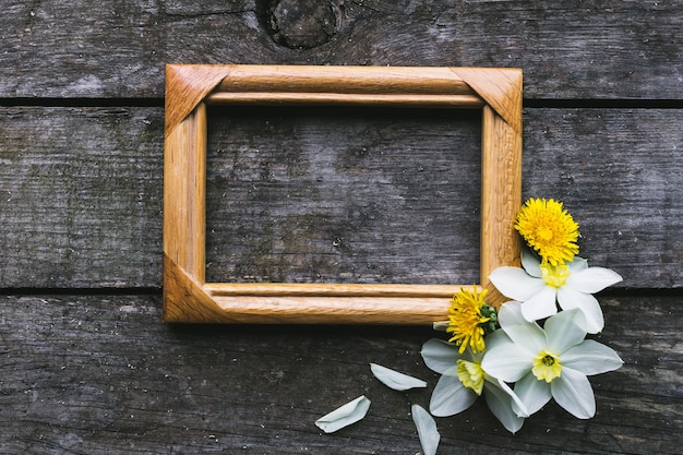 Flores de primavera y marco sobre un fondo de madera vieja