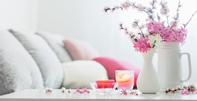 Flores de primavera rosa en florero en interior blanco