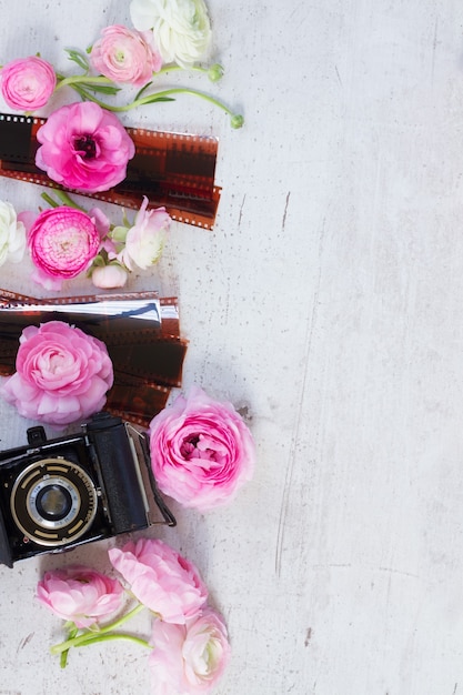 Flores de ranúnculo rosa y blanco con escena de endecha plana de cámara retro