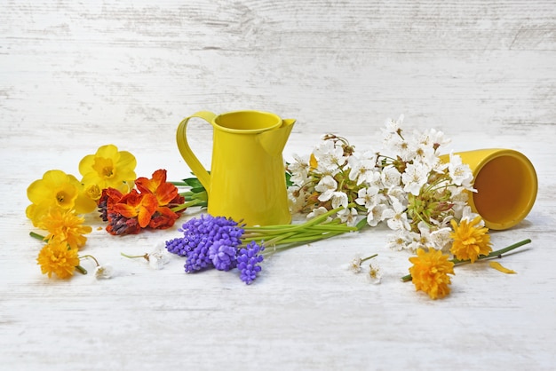 Flores recogidas del jardín y dispuestas sobre una mesa con lata amarilla