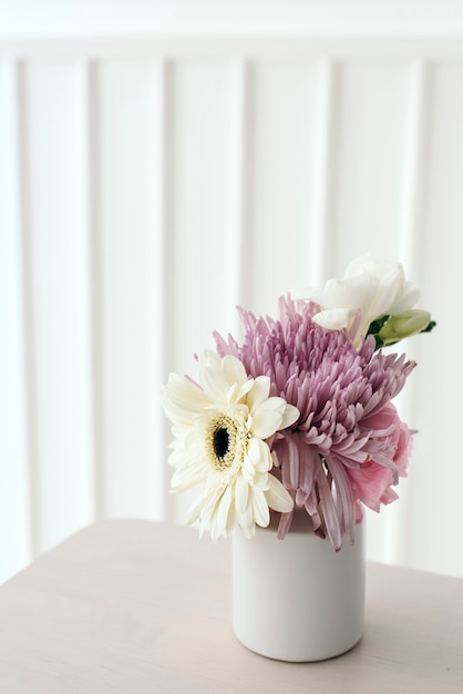 Flores rosas y blancas en un jarrón blanco