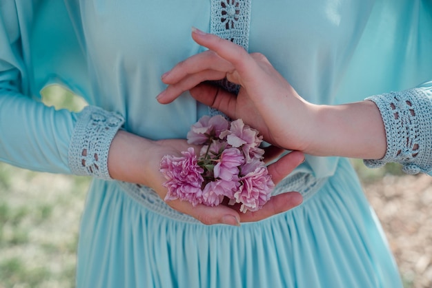 Flores rosas en manos de una niña.