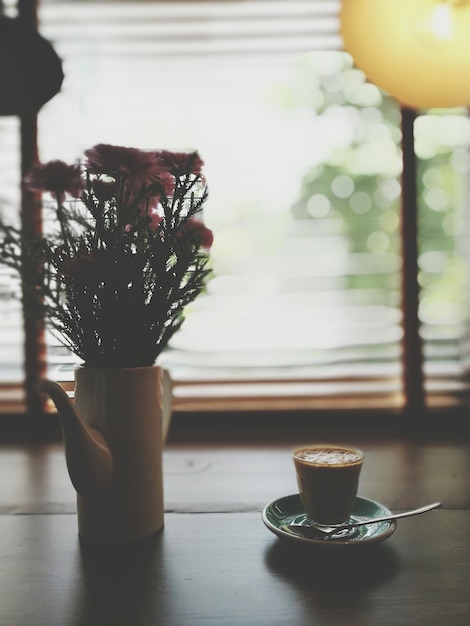 Flores rosas y taza de café en el interior