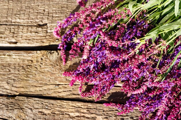 Foto flores roxas de sálvia em fundo de madeira rústica espaço de cópia de vista superior