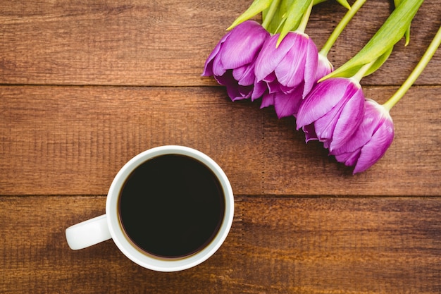 Flores roxas e uma xícara de café