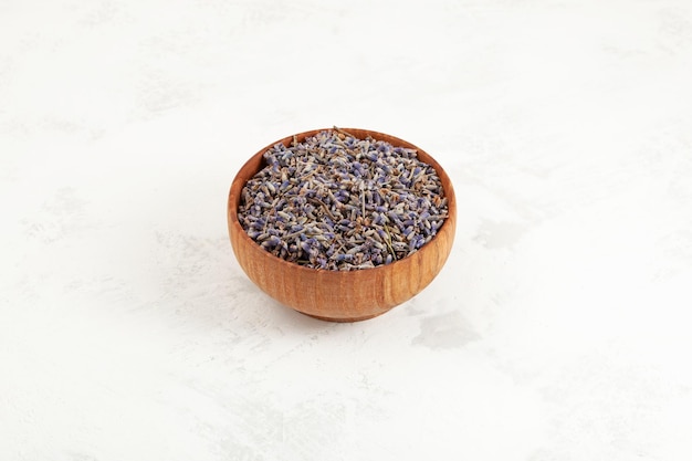 Flores secas de capullo de lavanda en un tazón de madera Té de hierbas púrpura con flores de lavanda secas naturales