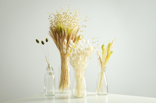 Flores secas conceito hygge em vasos na mesa