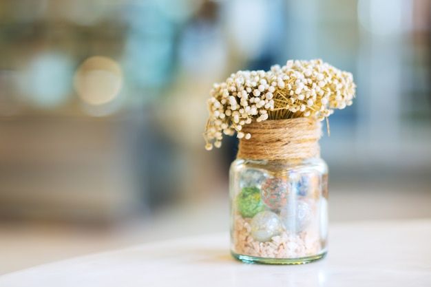 Flores secas em garrafa de vidro em decorações de mesa de madeira no café