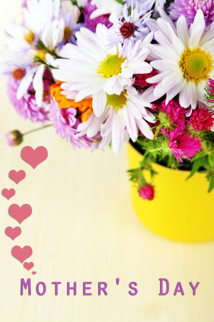 Foto flores silvestres en taza sobre mesa de madera