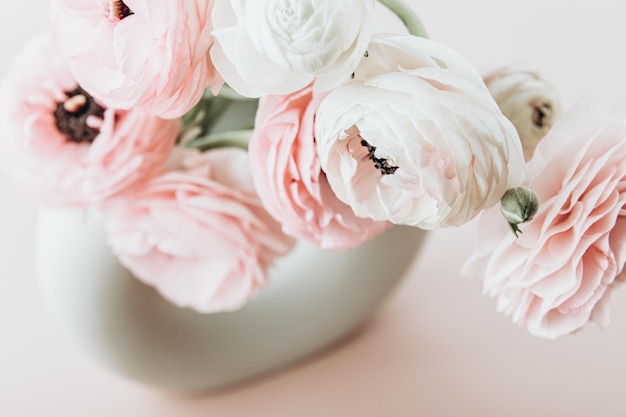 Flores tenras de ranúnculo em vaso de cerâmica