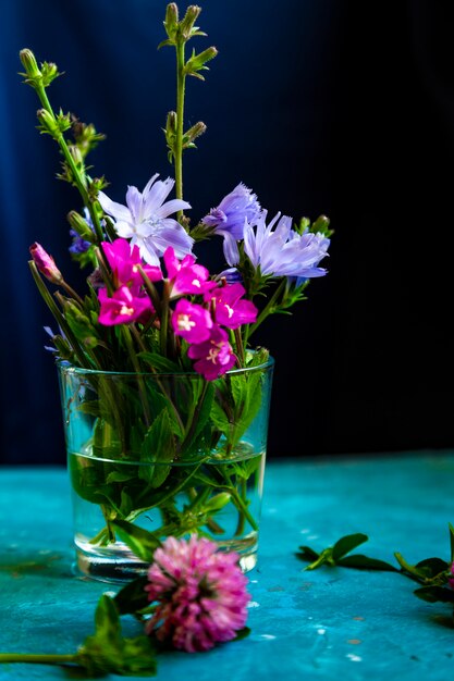 Flores de trébol rosa en mesa con fondo azul