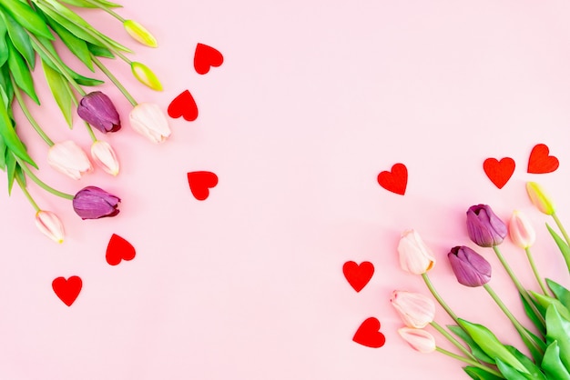 Flores de tulipán y corazones rojos en rosa