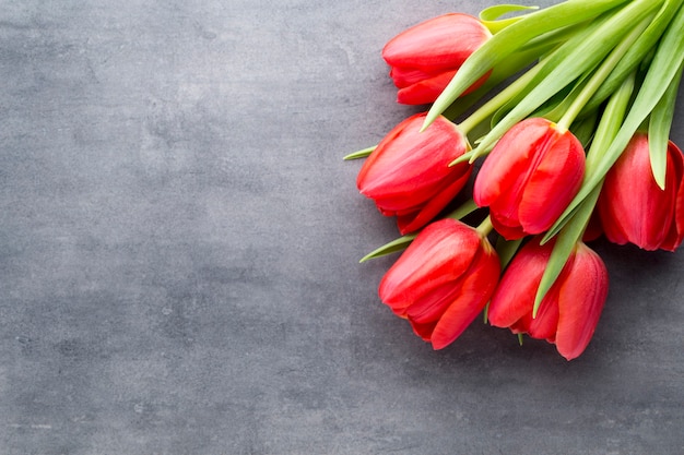 Flores de tulipán rojo sobre una superficie de madera