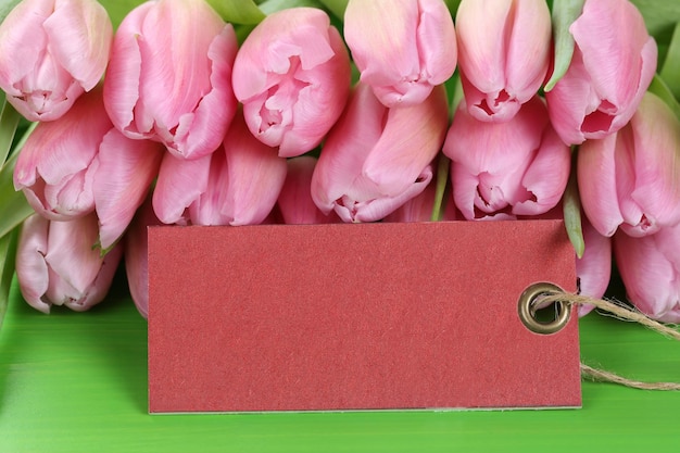 Flores de tulipanes en cumpleaños de primavera o día de la madre con etiqueta vacía y espacio de copia