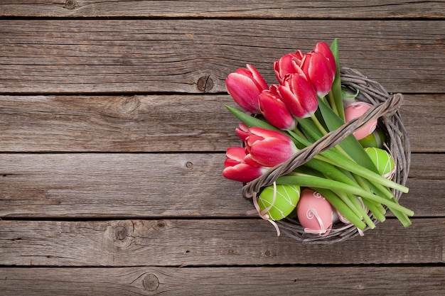 Flores de tulipanes rojos y huevos de pascua.