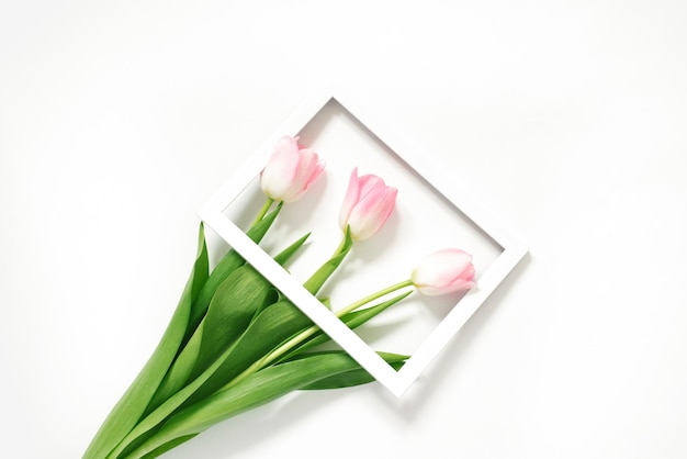 Flores tulipanes rosas en marco de fotos sobre fondo blanco Boda Cumpleaños Feliz día de la mujer Día de la madre