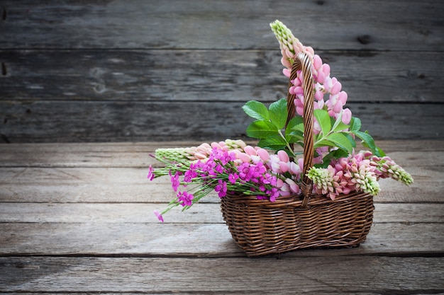 flores de verano en la canasta en la mesa de madera