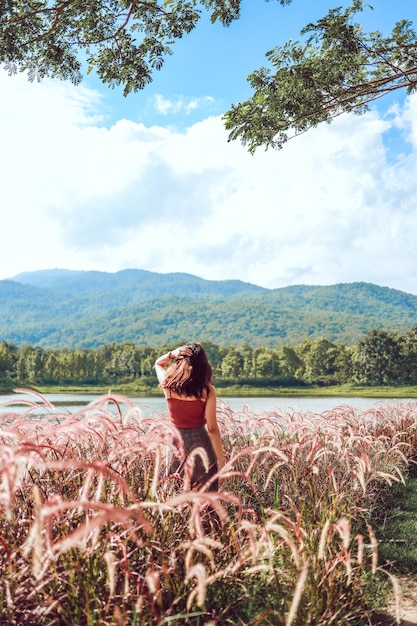 Flores de verano hermosas. Mujer asiática joven naturaleza fabulosa esperando el sol de verano en las vacaciones del prado