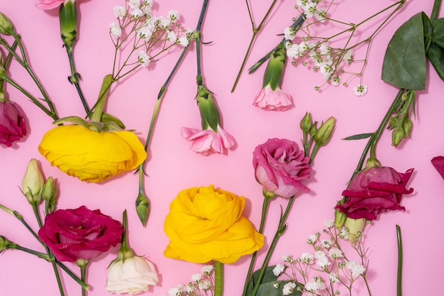 Foto flores vibrantes extendidas sobre un fondo rosado para una visión alegre