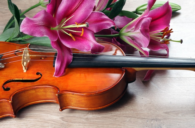 Flores de violín y lirio en una mesa de madera