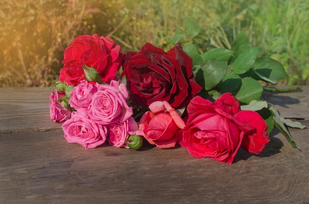 Florescência completa de rosas coloridas misturadas. flores de rosas de beleza. deliciosas flores em fundo de madeira.