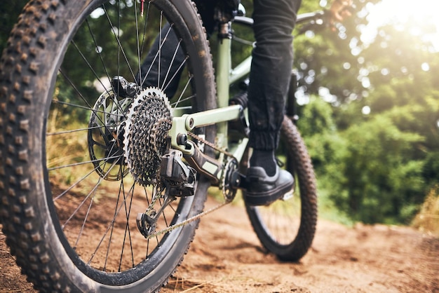 Floresta de bicicleta e rodas em uma trilha de estrada de terra para exercícios e exercícios de aventura fitness Closeup de uma pista de areia ao ar livre de bicicleta esportiva e pneu com um atleta andando de bicicleta na natureza por diversão e saúde