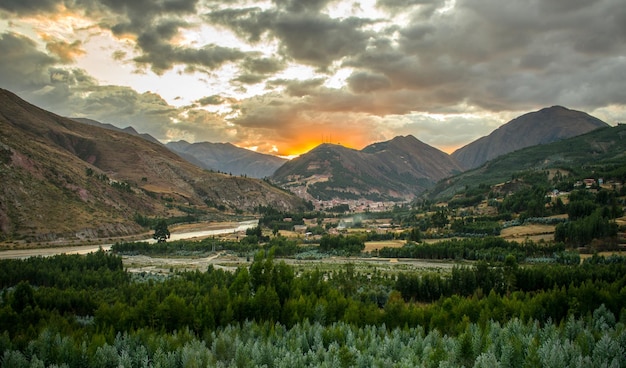 floresta próxima com montanhas distantes ao pôr do sol