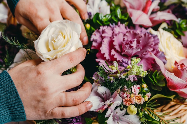 Florist bei der Arbeit macht einen modischen modernen Strauß aus verschiedenen Blumen.