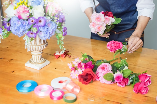 Florist, der schöne künstliche Weste am Blumenladen vereinbart