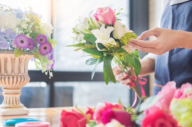 Florist, der schöne künstliche Weste am Blumenladen vereinbart