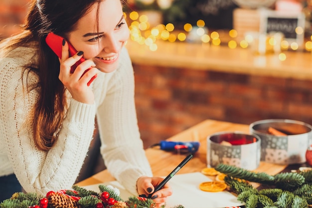 Florist home business Lächelnde Dame, die Bestellung per Telefon erhält Blur festliche Lichter Hintergrund