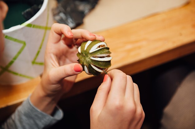 Florist macht einen Korb mit verschiedenen Blumen und Accessoires