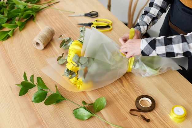 Florist macht einen Strauß frischer gelber Tulpen.