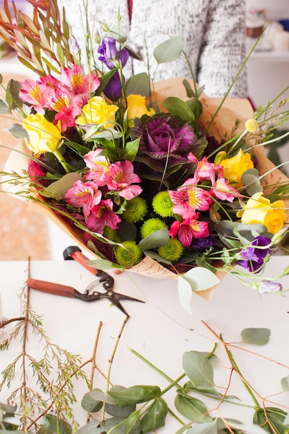 Florist macht Modestrauß aus bunten Blumen