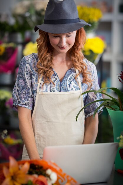 Florist mit Laptop im Blumenladen