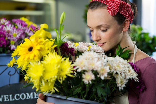 Florista cheirando um ramo de flores