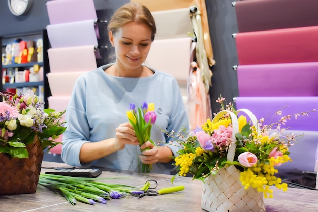 El florista colecciona ramo de flores Trabajar en una floristería Pequeña empresa de floristería