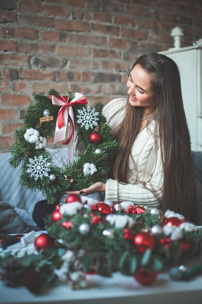 Florista com bolas de vidro de decorações de Natal, árvore de Natal perene e flocos de neve