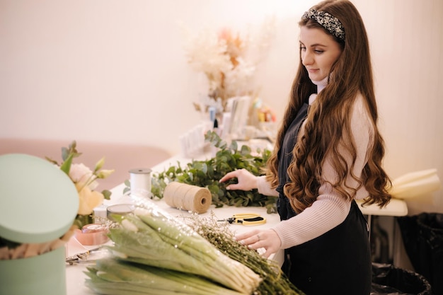 Florista de loja de entrega de flores criando pedido fazendo buquê de primavera feminino fazendo buquê usando tulipas