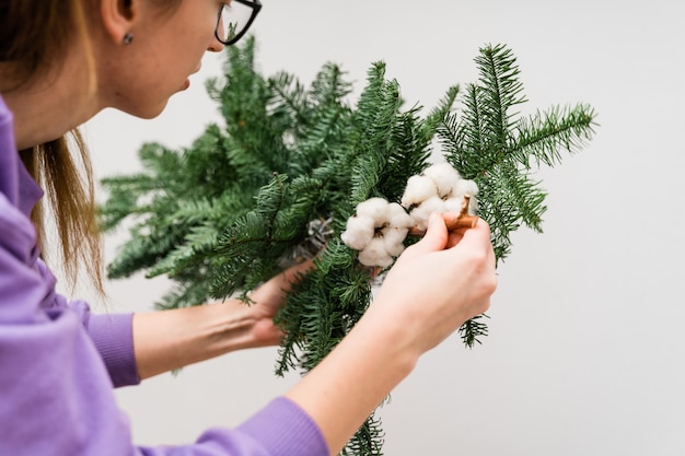 Foto florista de menina com uma guirlanda de pinheiros pendurados. decoração de florista de mulher.