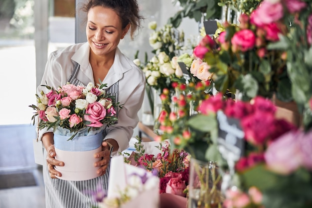 Florista encantadora posando com um ramo de flores bonitas