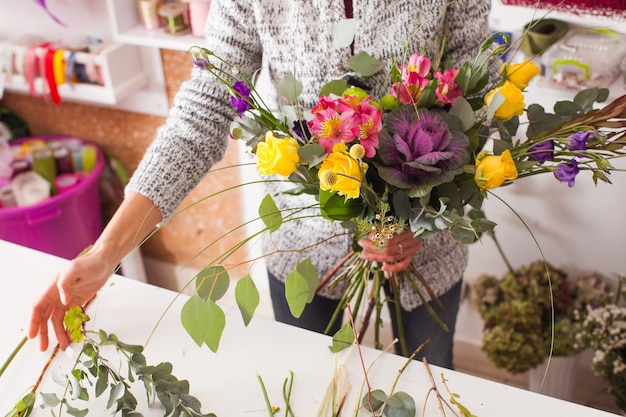 Florista fazendo buquê de flores coloridas