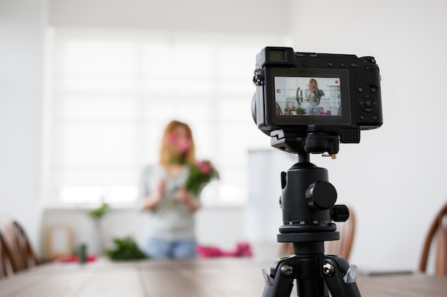 Florista fazendo buquê de flores cor de rosa. aula master de tiro na câmera de vídeo