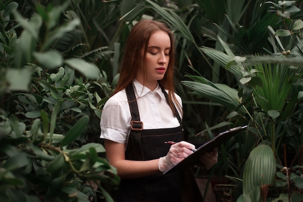 Florista feminina com prancheta na estufa