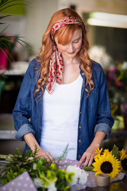 Florista feminina embrulho buquê de flores