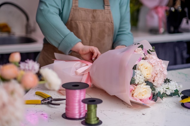 Florista feminina faz design floral para decorador de casamento preparando flores para aniversários e festas
