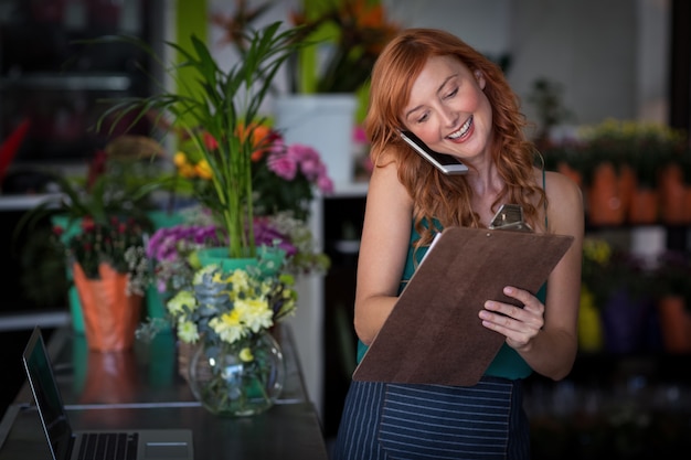 Florista feminina, levando a ordem no celular