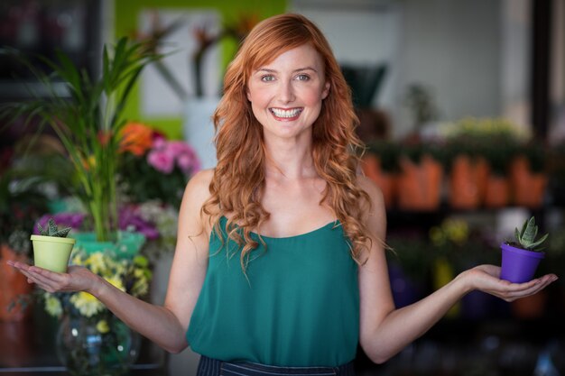 Florista feminina segurando o vaso na loja de flores