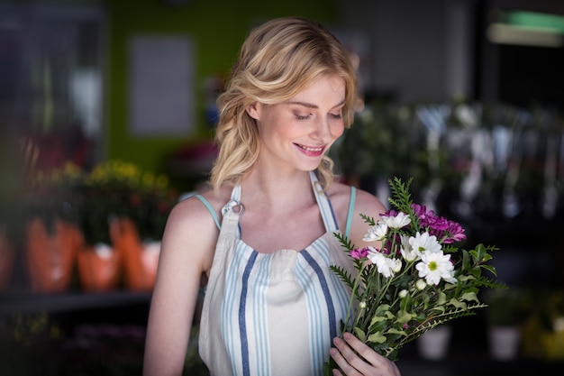 Florista feminina segurando ramo de flores na loja de flores