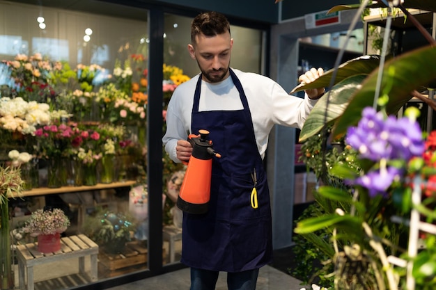 El florista jardinero se encarga de las flores en una tienda de ramos